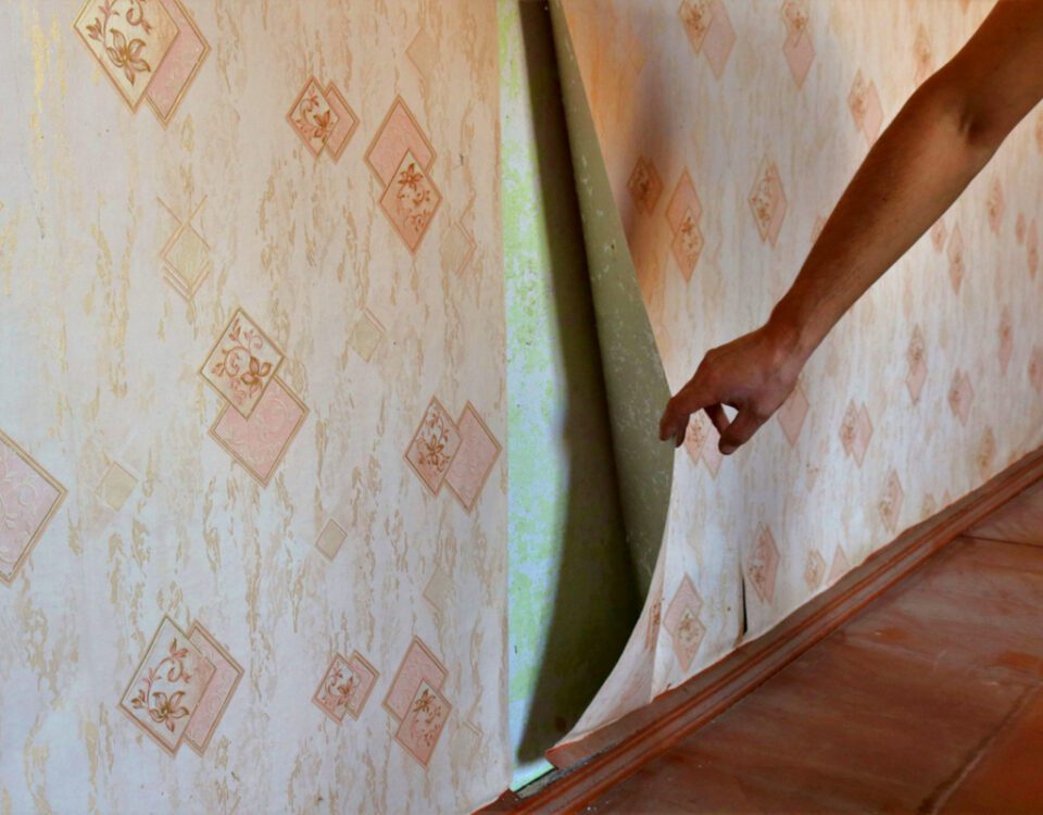 Painting over wallpaper - painter pulls back wallpaper in an old home