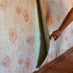 Painting over wallpaper - painter pulls back wallpaper in an old home