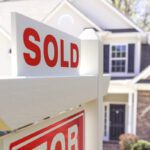 Home sold sign in front of house