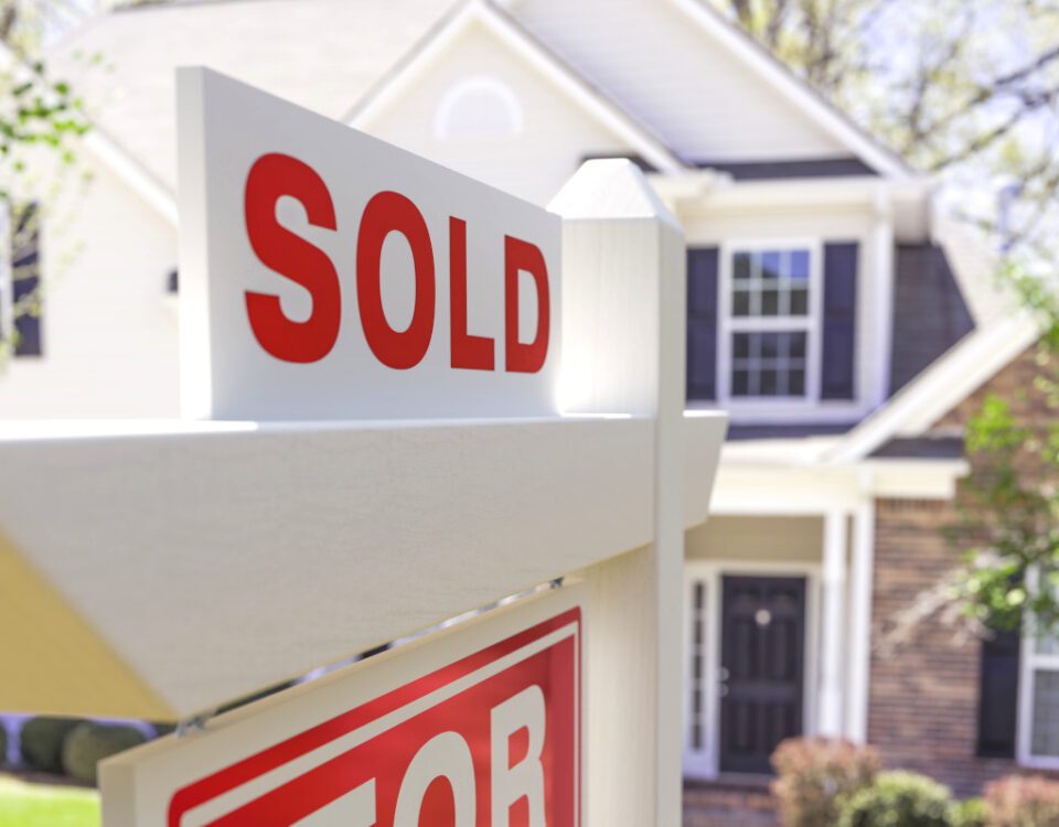 Home sold sign in front of house