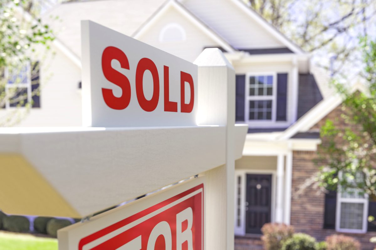 Home sold sign in front of house